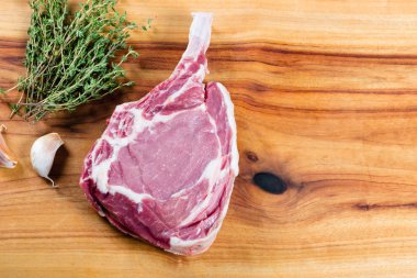 Otlar ile doğrama tahtası üzerinde Çiğ sığır viking biftek