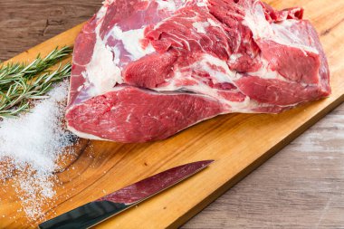 Otlar ile doğrama tahtası çiğ bütün sığır eti kıç