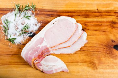 Otlar ile doğrama tahtası üzerinde Çiğ pastırma dilimleri