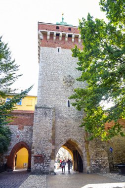 Turistler ve yerliler St Florian's Gate, ortaçağ kuleleri ve Krakow's Old Town, Polonya bir odak noktası ile Polonya gotik şehir savunma duvarları zaman harcama