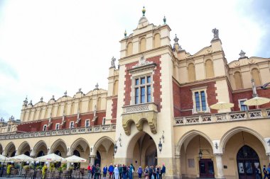 Turistler, Polonya 'nın Krakow Eski Kasabası' ndaki ana pazar meydanının merkezi özelliği olan Krakow Kumaş Salonu 'nda eğleniyorlar.