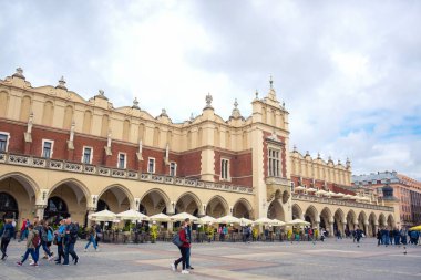 Turistler, Polonya 'nın Krakow Eski Kasabası' ndaki ana pazar meydanının merkezi özelliği olan Krakow Kumaş Salonu 'nda eğleniyorlar.