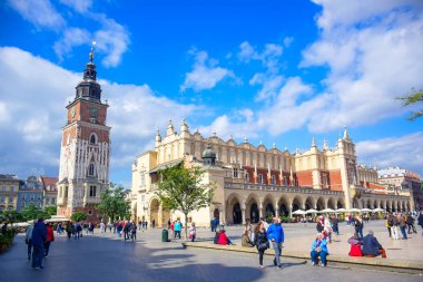 Turistler, Polonya 'nın Krakow Eski Kasabası' ndaki ana pazar meydanının (Main Square) merkezindeki Krakow Kulesi ve Kulesi 'nde eğleniyorlar.