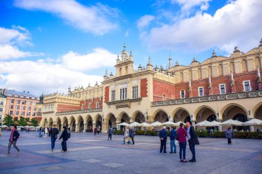 Turistler, Polonya 'nın Krakow Eski Kasabası' ndaki ana pazar meydanının merkezi özelliği olan Krakow Kumaş Salonu 'nda eğleniyorlar.