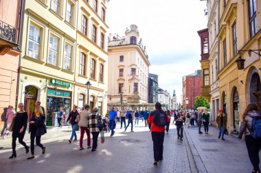 Turistler ve Polonyalı yerliler Polonya 'nın Krakow kentinde sokak boyunca yürümenin keyfini çıkarıyorlar.