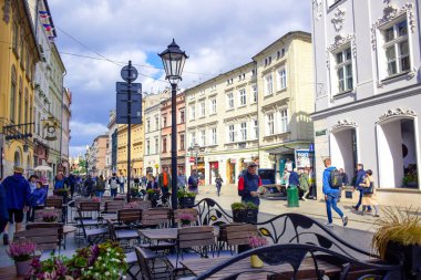 Turistler ve Polonyalı yerliler Polonya 'nın Krakow kentinde sokak boyunca yürümenin keyfini çıkarıyorlar.
