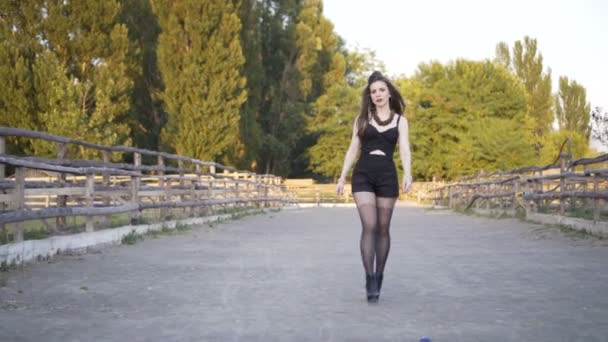 Ung kvinna promenerar längs stora vägen i soligt väder — Stockvideo