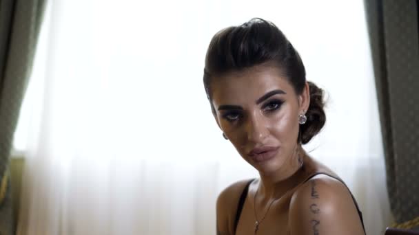 Leidenschaftliches schönes Model, das im Hotel auf dem Bett liegt und für Fotos posiert — Stockvideo
