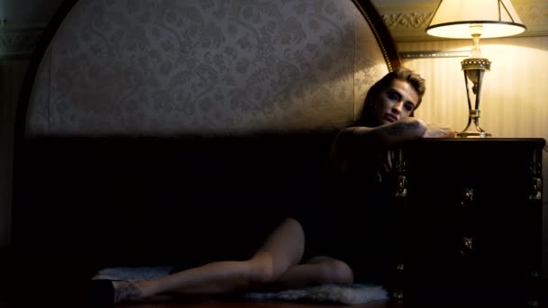 Leidenschaftliches schönes Model, das im Hotel auf dem Bett liegt und für Fotos posiert — Stockvideo
