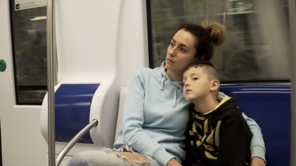 Matka i syn, podróż pociągiem metra. Zmęczony i śpiący chłopiec leżący na kolanach matek, Kobieta, gładząc głowę — Wideo stockowe