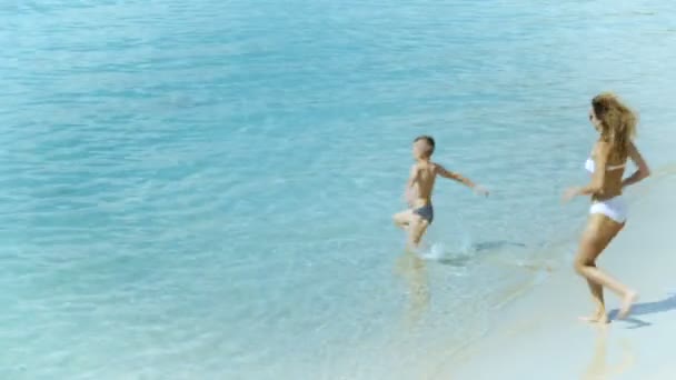 Mãe brincando com seu filhinho e correndo no mar na praia tropical — Vídeo de Stock