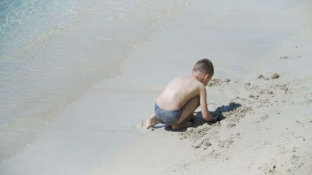 Kind spielt am Strand — Stockvideo