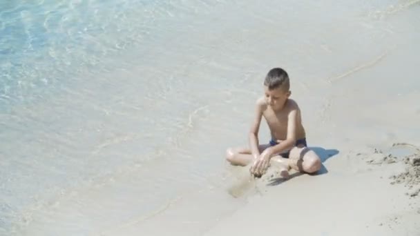 Niño jugando en la playa — Vídeo de stock