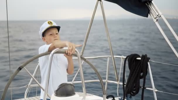Kleiner Junge steuert eine Segeljacht — Stockvideo