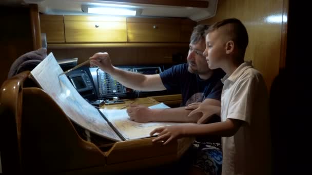 Father and son looking at map on the sailboat — Stock Video