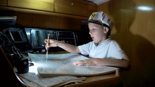 Niño capitán del yate pavimenta la ruta en el mapa — Vídeos de Stock