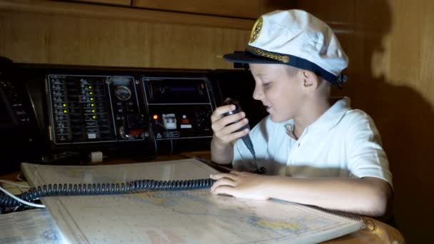 Kind schipper praten over walkie-talkie radio in cockpit op schip — Stockvideo