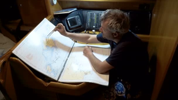 Капитан яхты прокладывает маршрут на карте — стоковое видео