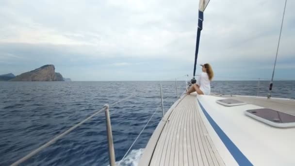 Hermosa joven en blanco en el arco del yate — Vídeo de stock