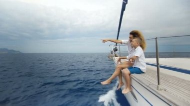 Oğlu ile denizde Yelkenli tekne yay üzerinde oturan kadın