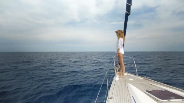 Schöne junge Frau in Weiß auf dem Bug der Jacht — Stockvideo