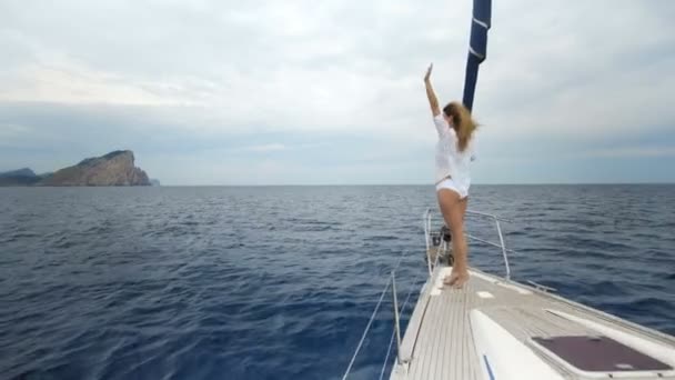 Hermosa joven en blanco en el arco del yate — Vídeos de Stock