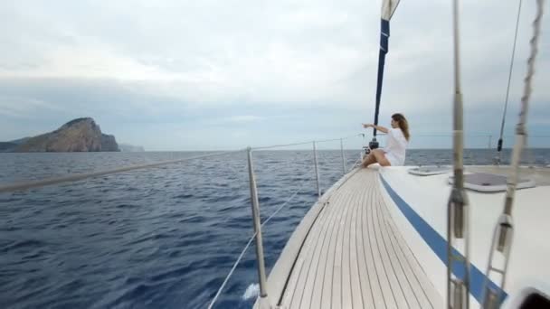 Bella giovane donna in bianco sulla prua dello yacht — Video Stock