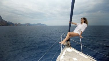 Güzel kız mayo yay yat ve deniz sunbaths oturur