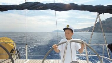 Litle çocuklar Kaptan bir yelkenli yat yarışı sırasında Dümen kontrolleri.