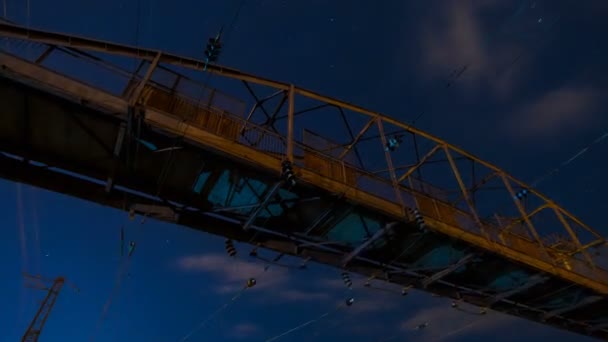 Brug tegen de achtergrond van de sterrenhemel van de avond. De hemel verandert in nacht en meerdere sterren timelaps verschijnen. — Stockvideo