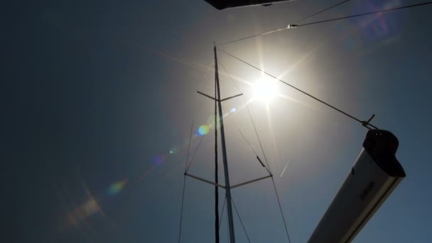 La vela 4K se llena de viento, navegando bajo el sol de verano, la luz del sol se enciende en la cámara — Vídeo de stock