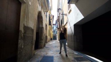 Arka görünümü turist kadın yürüyüş dar sokaklarında Avrupa yaz tatil seyahat tatil macera zevk Barcelona giyen şirin yazlık elbise