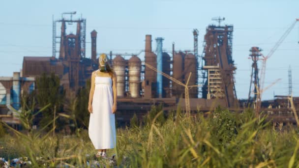 工場の煙のようなパイプの背景に防毒マスクの女 — ストック動画