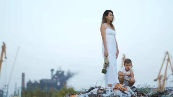 Anne ve oğlu. Çöplüğü. Endüstriyel Fabrika arka plan üzerinde. Çevre kirliliği kavramı. — Stok video