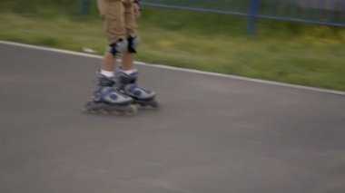 Tekerlekli paten sürmek. Çocuk silindirler üzerinde rulo