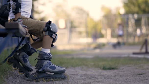 Jambes d'un enfant en patins à roulettes. L'enfant roule sur des rouleaux . — Video