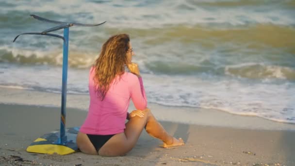 Chica en la playa con un hidroplano tablero — Vídeo de stock