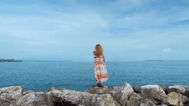 dívku v krásných šatech stojí na pobřeží