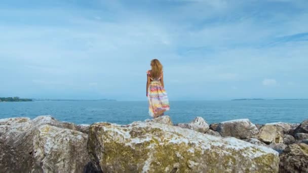 Mädchen in schönem Kleid steht an der Küste — Stockvideo