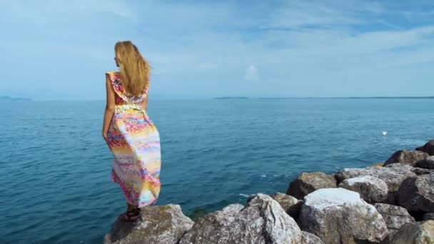 Menina Vestido Bonito Pedras Olhando Para Oceano — Vídeo de Stock