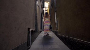 Güneşli bir günde küçük Caddede yürüyen genç turist kadın. Eski şehir keşfetmek Avrupa'da tatil harcama kız.