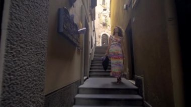 Güneşli bir günde küçük Caddede yürüyen genç turist kadın. Eski şehir keşfetmek Avrupa'da tatil harcama kız.