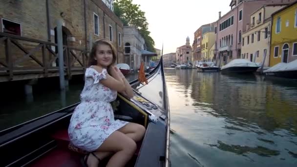 ドレスを着て、イタリアのベニスのゴンドラに乗って美しい少女. — ストック動画