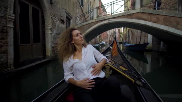 ゴンドラで若い女性帆ヴェネツィアの橋の下 — ストック動画