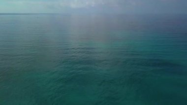 Hava atış, bulutlar, beyaz plaj çok sakin deniz, büyük su kirliliği nedeniyle oluşturulan dolu inanılmaz güzel sakin deniz uçağı ile filme