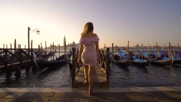 Girl walking on the water deck near gondolas. — Stock Video