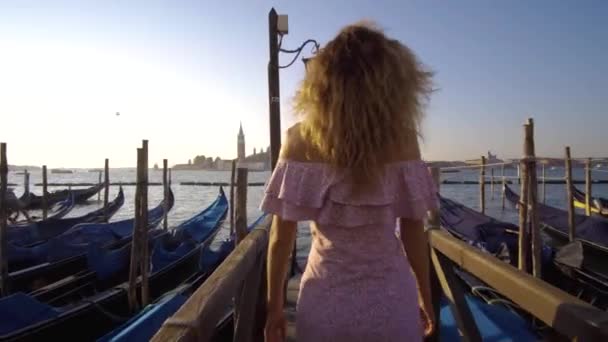 Flicka som går på vatten däck nära Gondoler. — Stockvideo