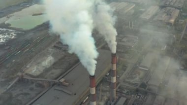 Büyük kırmızı ve beyaz boru kalın beyaz bir duman ile organize sanayi bölgesinde güneş aksine fabrika borudan dökülür. Havadan görünümü