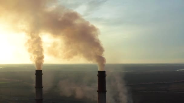 Zona industrial com um grande tubo vermelho e branco espessa fumaça branca é derramada a partir do tubo de fábrica em contraste com o sol. Poluição do ambiente: um tubo com fumo. Vista aérea — Vídeo de Stock