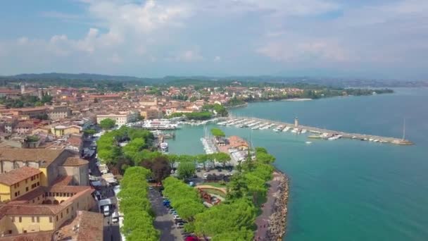 Vista aérea de barcos y costa del lago de Garda, Italia. Volar sobre los barcos y la costa del Lago di Garda en vacaciones de verano . — Vídeo de stock